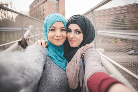 Two female friends on footbridge taking selfie