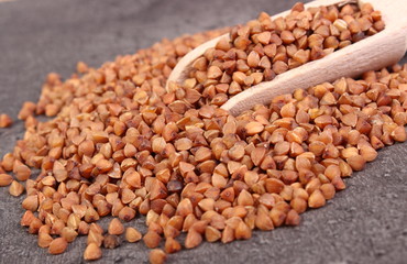 Buckwheat groats with spoon on cement structure