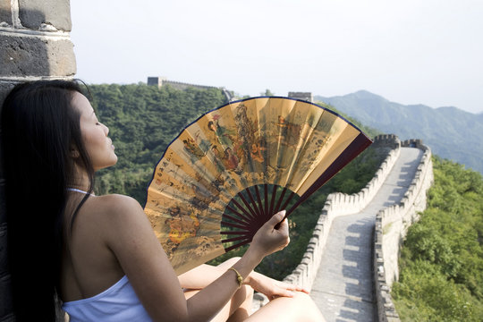 Rear view of mid adult female tourist holding fan on the Great Wall of China, Beijing, China