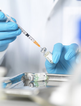 Close up of doctors hands preparing a vaccine to inject  patient