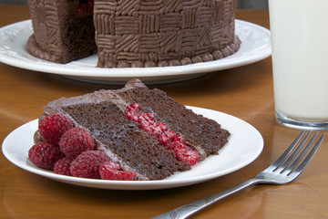 A Slice of Raspberry Chocolate Cake with milk, close up