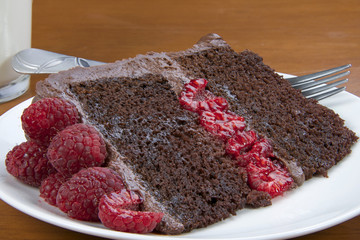 A Slice of Raspberry Chocolate Cake with milk, close up