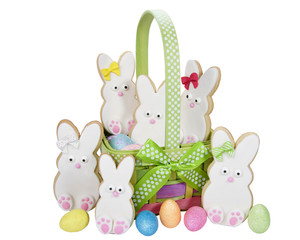 Home made designer Easter Bunny Cookies standing up in a basket, easter eggs, isolated on white
