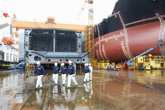 Workers walking across shipyard, GoSeong-gun, South Korea