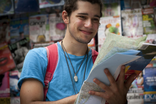 Young male tourist reading map, Copacabana town, Rio De Janeiro, Brazil