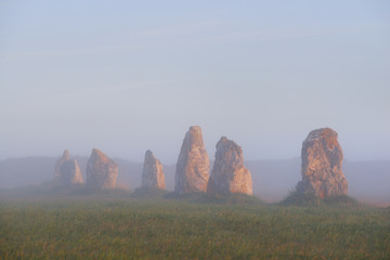 Menhir alignment view at Camaret sur mer at sunrise during fog