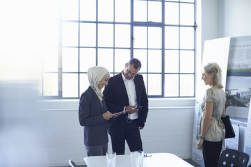 Mature businesswoman presenting ideas to team in office