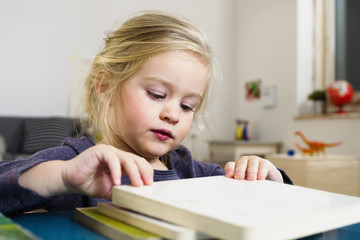 Girl arranging square blocks on table