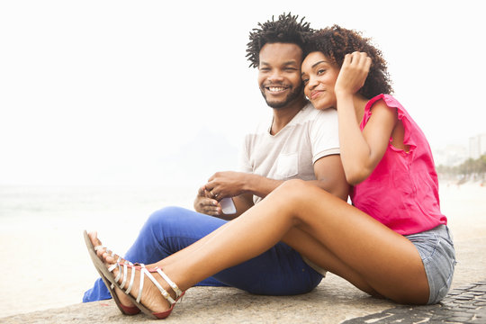 Portrait Of Romantic Couple Sitting, Ipanema Beach, Rio De Janeiro, Brazil