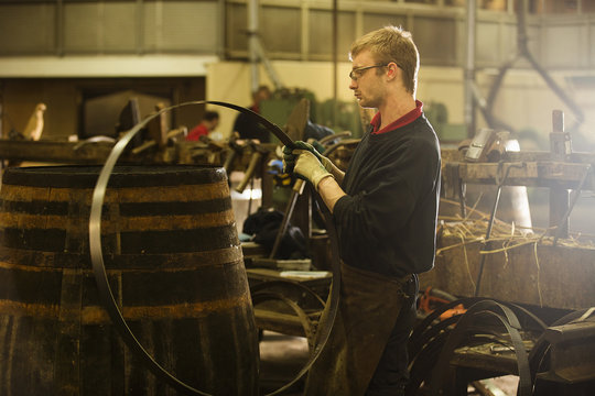 Male cooper making whisky casks in cooperage