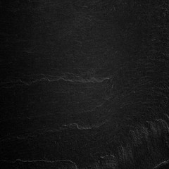 Dark grey black slate background or natural stone texture.