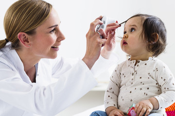 Paediatrician checking baby boy's eyes