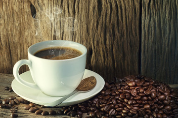 Coffee cup and coffee beans on a wood background