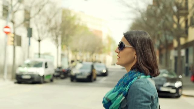 Woman crossing street in the city, steadycam shot

