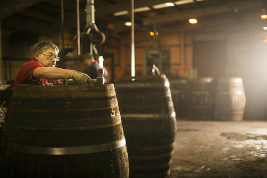 Mature man making whisky cask in cooperage