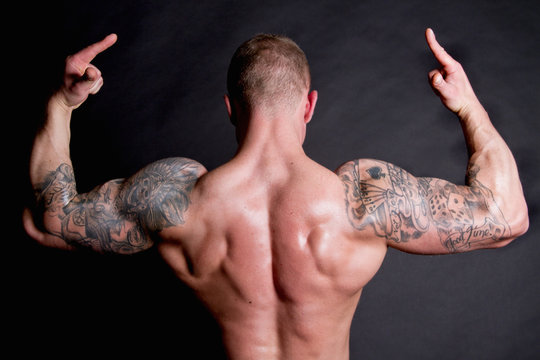 Young man showing rear double biceps