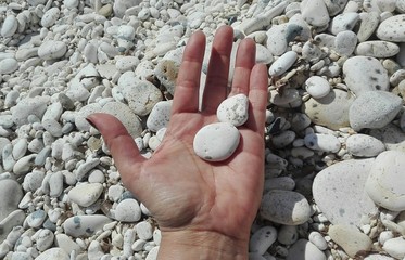 Mano con ghiaie bianche