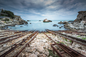 Old shipwreck long exposure on the rocks at sunset