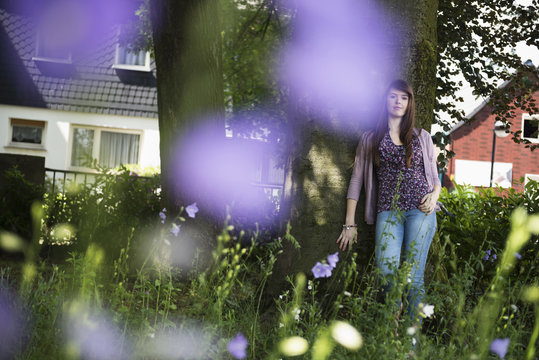 Woman standing by tree