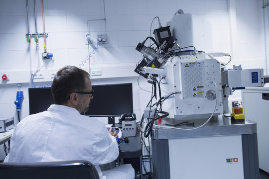 Lab assistant working with scanning electron microscope
