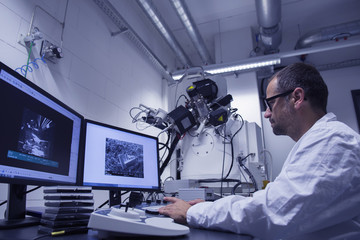 Lab assistant working with SEM image on computer