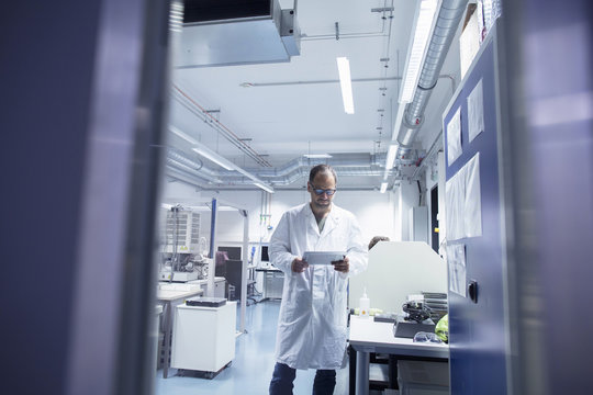 Lab assistant checking details on digital tablet