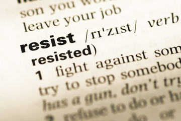 Close up of old English dictionary page with word resist