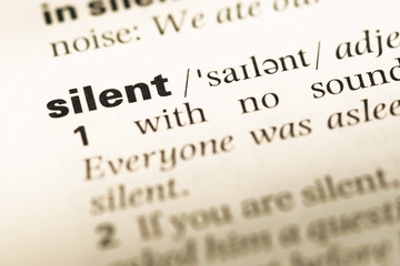 Fototapeta premium Close up of old English dictionary page with word silent