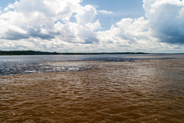 Fototapeta premium The Meeting of Waters (Encontro das Aguas) is the confluence between the Rio Negro river, with dark water, and lighter Amazon river or Rio Solimoes