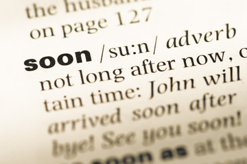 Obraz premium Close up of old English dictionary page with word soon