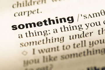 Obraz premium Close up of old English dictionary page with word something