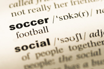Close up of old English dictionary page with word soccer