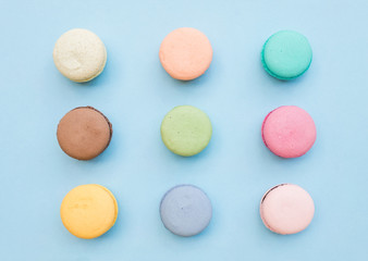 Sweet colorful French macaroon biscuits on pastel blue background