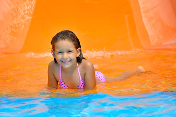 Adorable toddler girl enjoying her summer vacation at aquapark