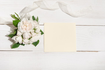 white roses with empty card for you text on white table.top view