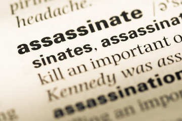 Close up of old English dictionary page with word assassinate