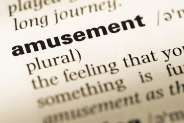 Obraz premium Close up of old English dictionary page with word amusement