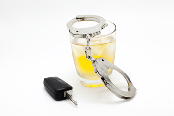 Car key with glass of whiskey and handcuffs - drive under influence concept