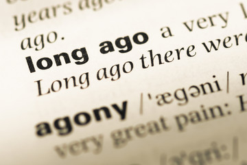 Close up of old English dictionary page with word long ago