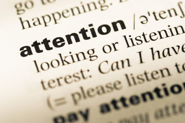 Close up of old English dictionary page with word attention