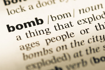 Obraz premium Close up of old English dictionary page with word bomb