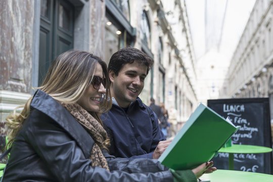 Couple reading lunch menu in Galeries Royales Saint-Hubert, Brussels, Flanders, Belgium