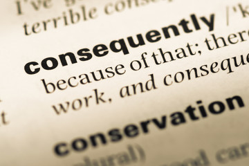 Close up of old English dictionary page with word consequently