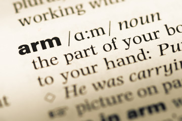 Obraz premium Close up of old English dictionary page with word arm