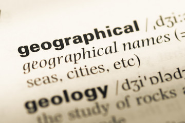 Close up of old English dictionary page with word geographical