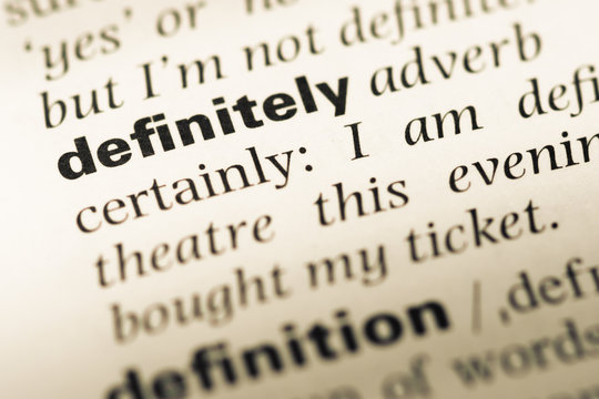 Close up of old English dictionary page with word definitely