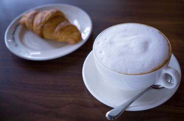 hot coffee and fresh croissant on table