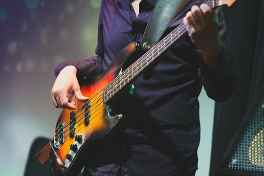 Rock and roll music, bass guitar player closeup