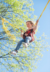 Little girl on bungee trampoline with cords.