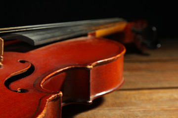 Fototapeta na wymiar violin on wooden brown background closeup